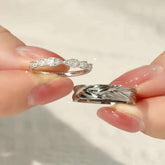 hand holding sterling silver couple rings with leaf and polished design